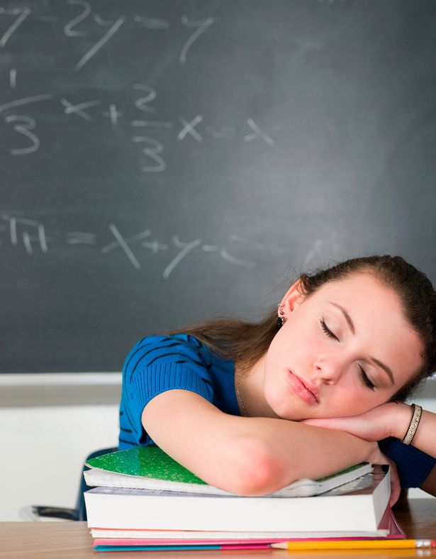 0 Bored student sleeping at desk in classroom